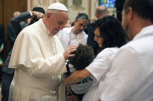 A Assise le pape bénit un enfant handicapé